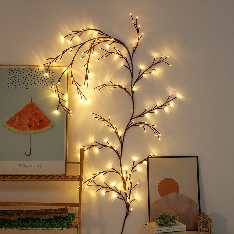 LED rattan twig branch lights in a vase beside a framed print