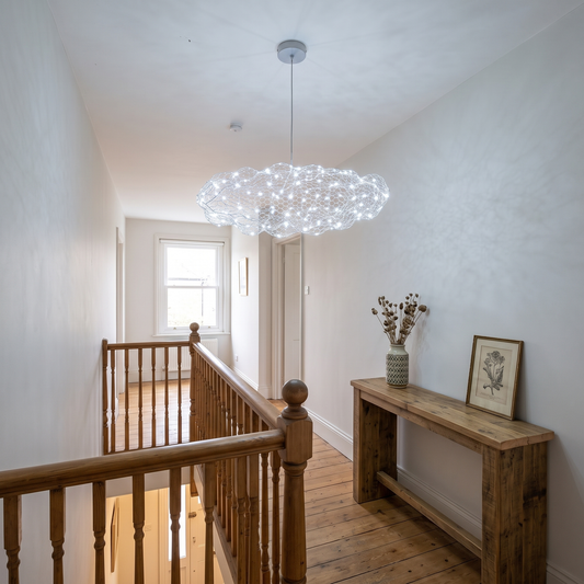 Silver wire mesh cloud pendant light lit cool white on a UK landing above a console table, starry LED points glowing in the mesh
