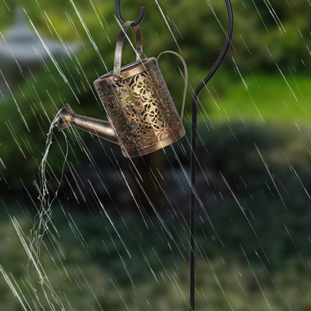 Decorative hollow iron solar watering can garden ornament daytime view
