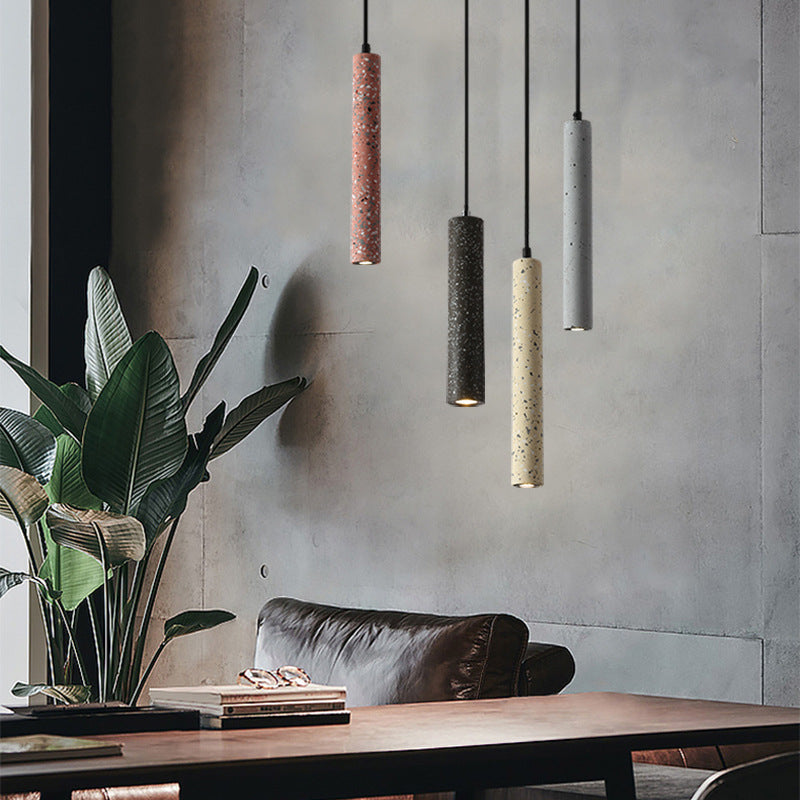 Three terrazzo tube pendants over a living room side table
