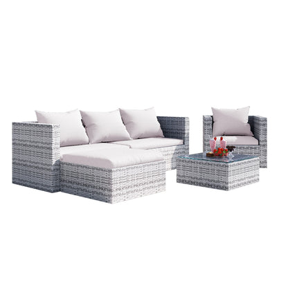 4 seater rattan set in garden with plants background