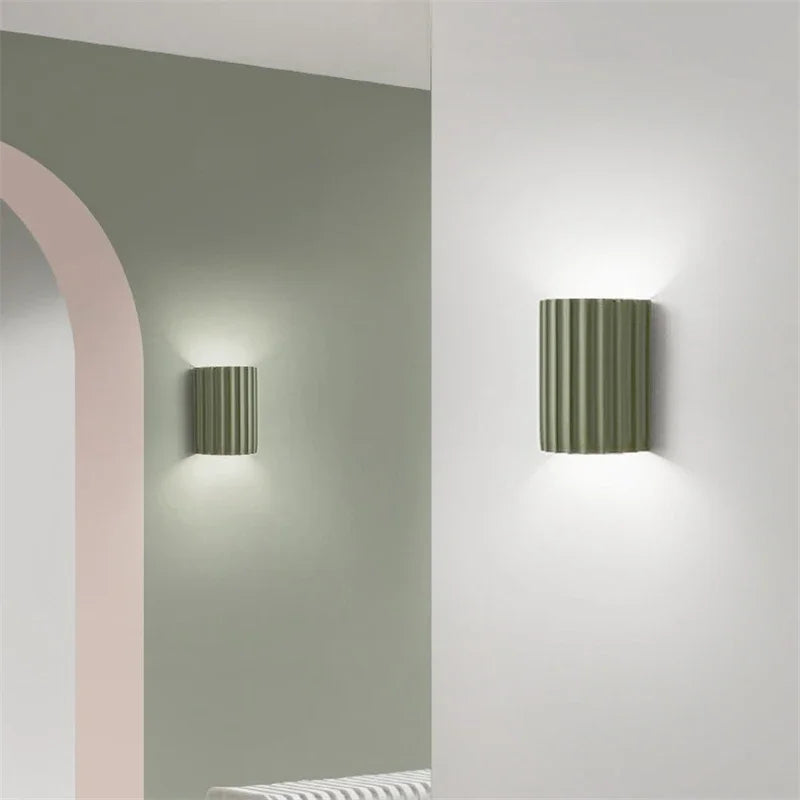 Sage green curved resin wall lights lighting a hallway arch