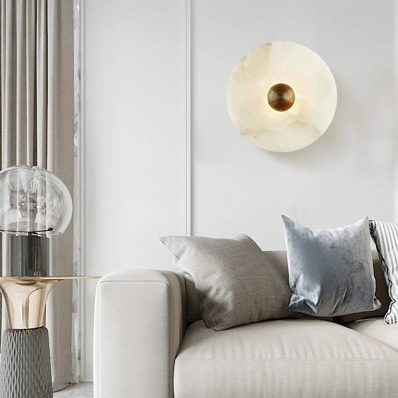 Marble wall light lit above a sofa in a bright living room