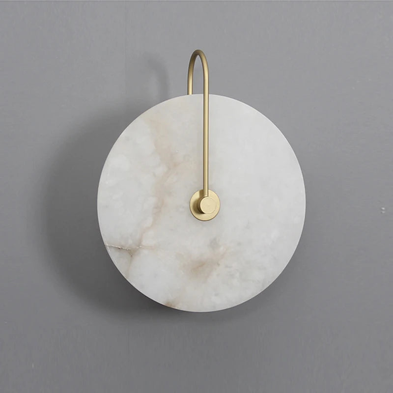 Large marble disc wall light with slim gold arm on a grey wall
