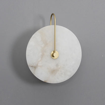 Large marble disc wall light with slim gold arm on a grey wall
