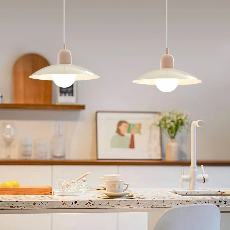 Pair of macaron saucer pendant lights above a kitchen counter