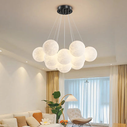 Moon globe bubble chandelier lit above a living room sofa
