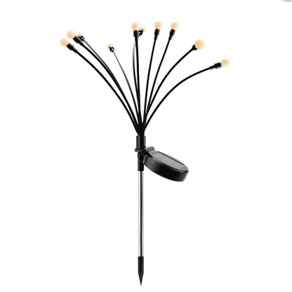 Solar firefly garden lights swaying above lawn and planting at night