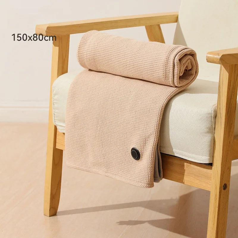 Heated throw shawl blanket folded on a chair, 150cm by 80cm