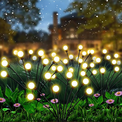 Warm white solar firefly stake lights lighting a garden pathway at dusk