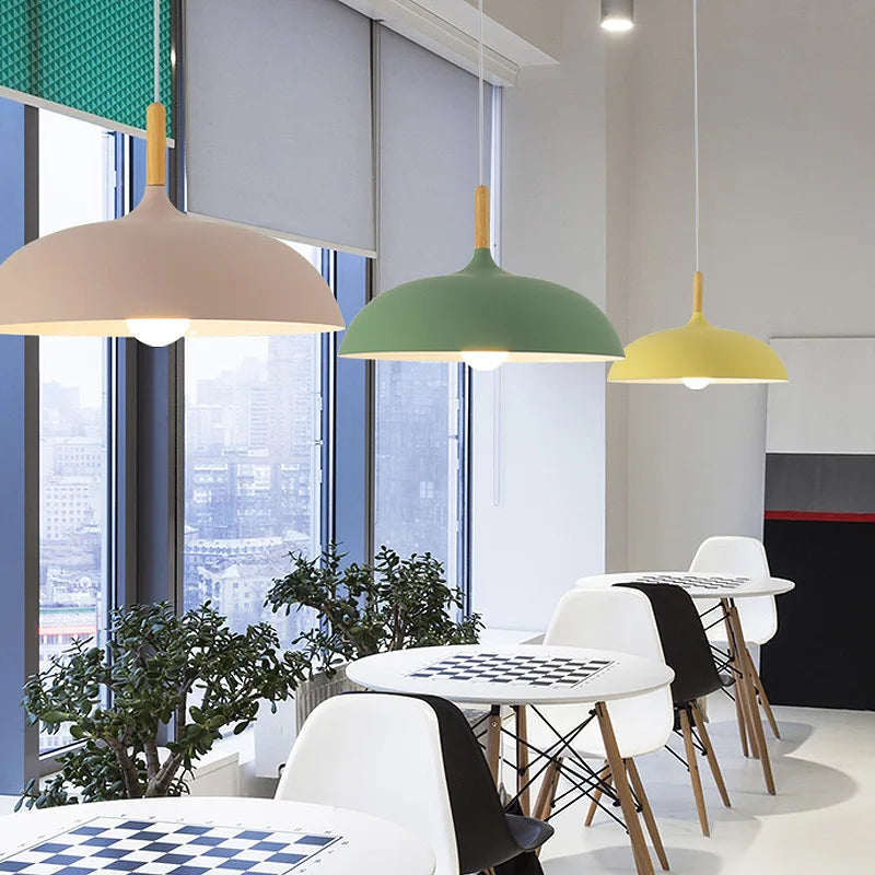 Macaron dome pendant lights with oak stems hung in a row above a kitchen island