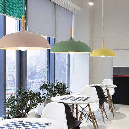 Macaron dome pendant lights with oak stems hung in a row above a kitchen island