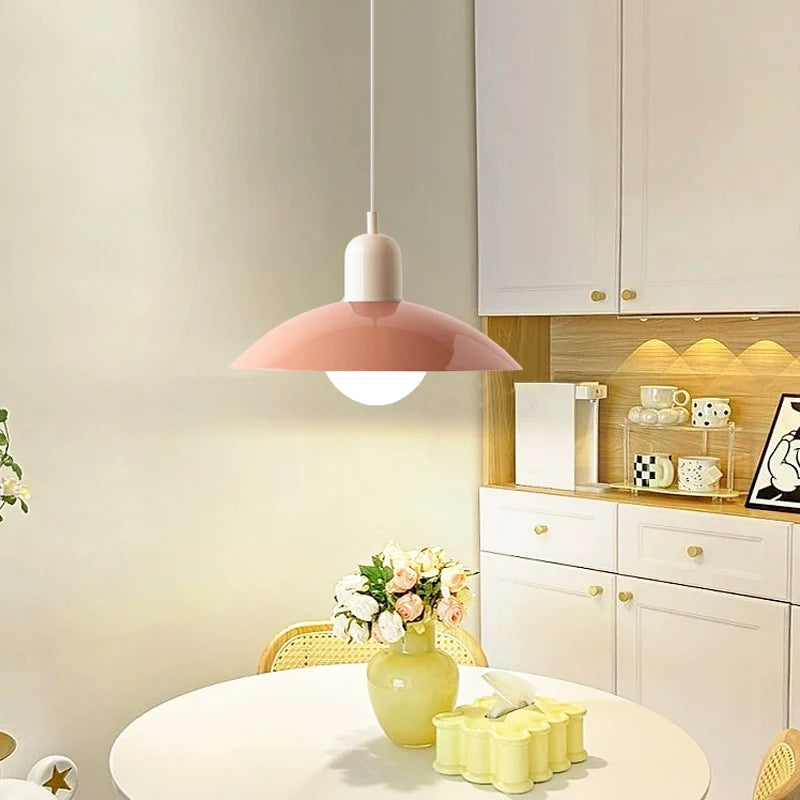 Macaron saucer pendant light lit above a dining table with flowers