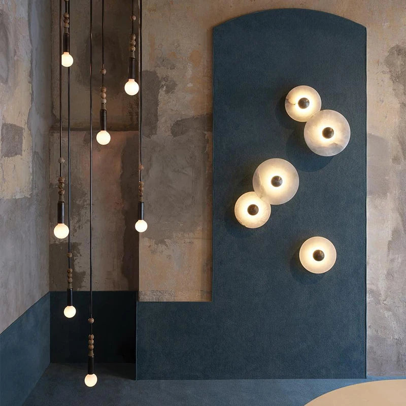 Marble disc wall lights arranged on a deep blue feature wall
