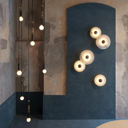 Marble disc wall lights arranged on a deep blue feature wall