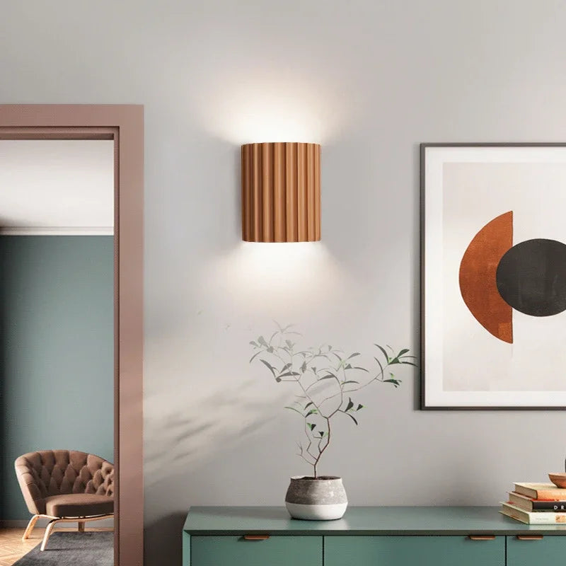 Terracotta sculpted resin wall light above a sideboard in a living room