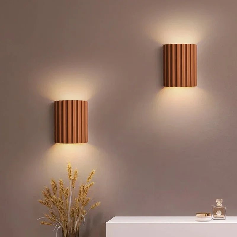 Pair of terracotta resin wall lights washing light up a bedroom wall