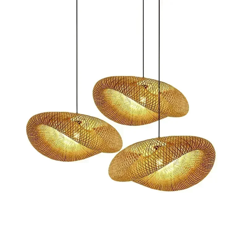 Three hand woven bamboo pebble lamp shades on a plain background