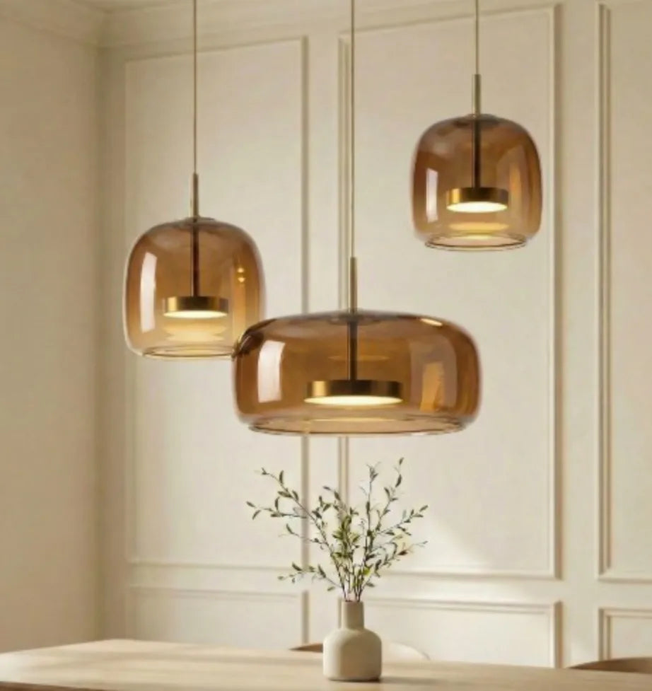Amber glass kitchen island pendant light lit above a breakfast bar