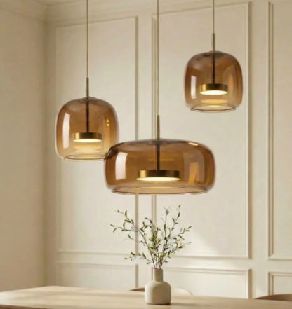 Amber glass kitchen island pendant light lit above a breakfast bar