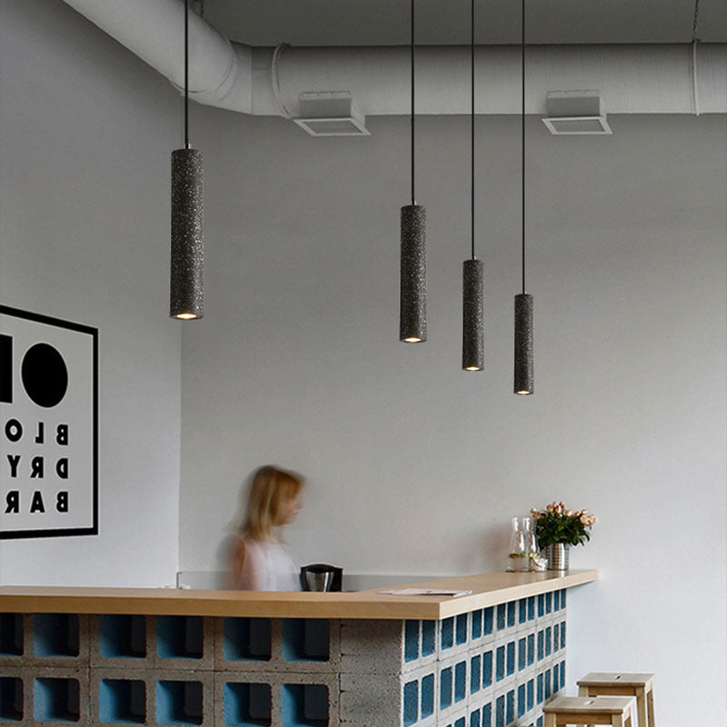 Terrazzo tube pendants in a row over a café counter