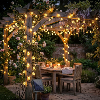 Solar crystal globe fairy lights wrapped around a garden pergola at night with warm sparkling effect