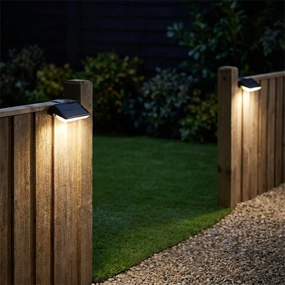 Solar wall lights mounted on garden fence posts casting warm downward glow at night