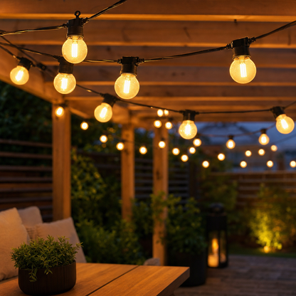 Solar festoon string lights 10m draped across garden patio with warm white Edison bulbs glowing