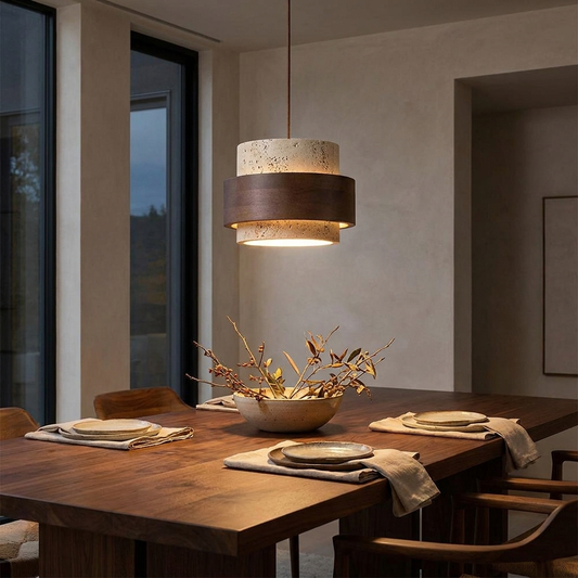 Luma travertine stone pendant light hanging over a wooden dining table in a minimalist interior