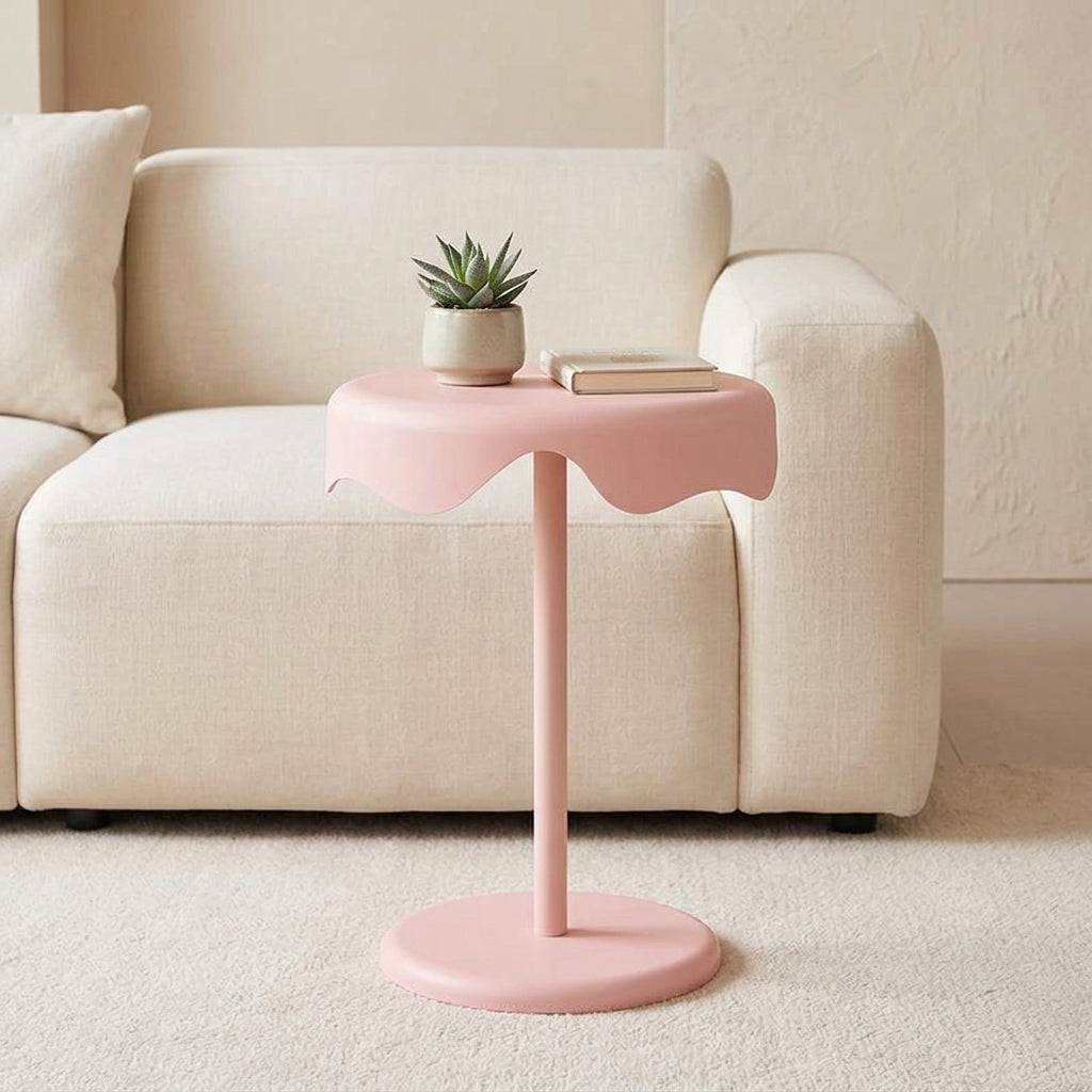 Blush pink round bedside side table styled beside bed in bright modern bedroom