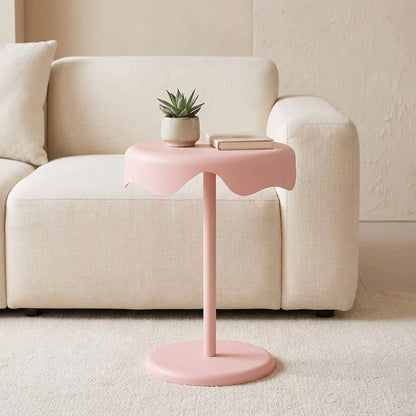 Blush pink round bedside side table styled beside bed in bright modern bedroom