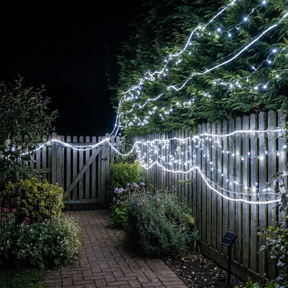Solar fairy lights - cool white twinkling along a garden fence at night