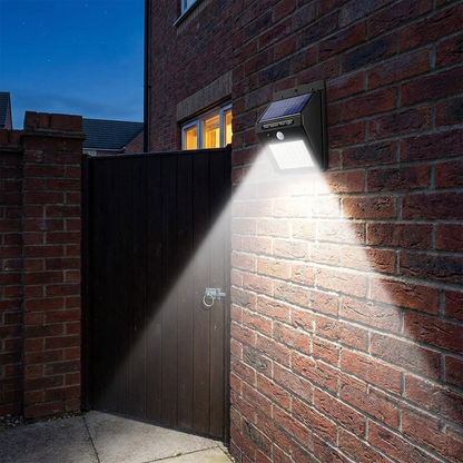 Solar PIR security wall light mounted above a side gate at dusk