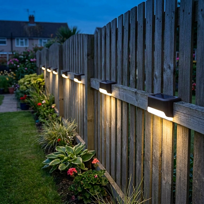Solar deck lights mounted along a timber garden fence at dusk