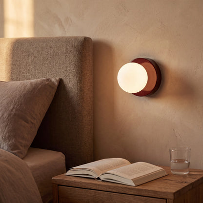 Oxblood red mini macaron glass globe wall sconce, wall mounted in a UK reading corner