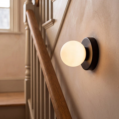 Black mini macaron glass globe wall sconce, wall mounted in a UK hallway