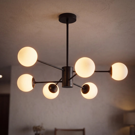 Modern glass globe chandelier with 6 lights and a black frame, lit above a living room