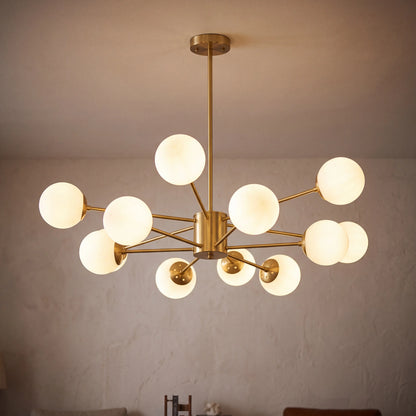 Modern glass globe chandelier with 12 lights and a gold frame, lit in a living room