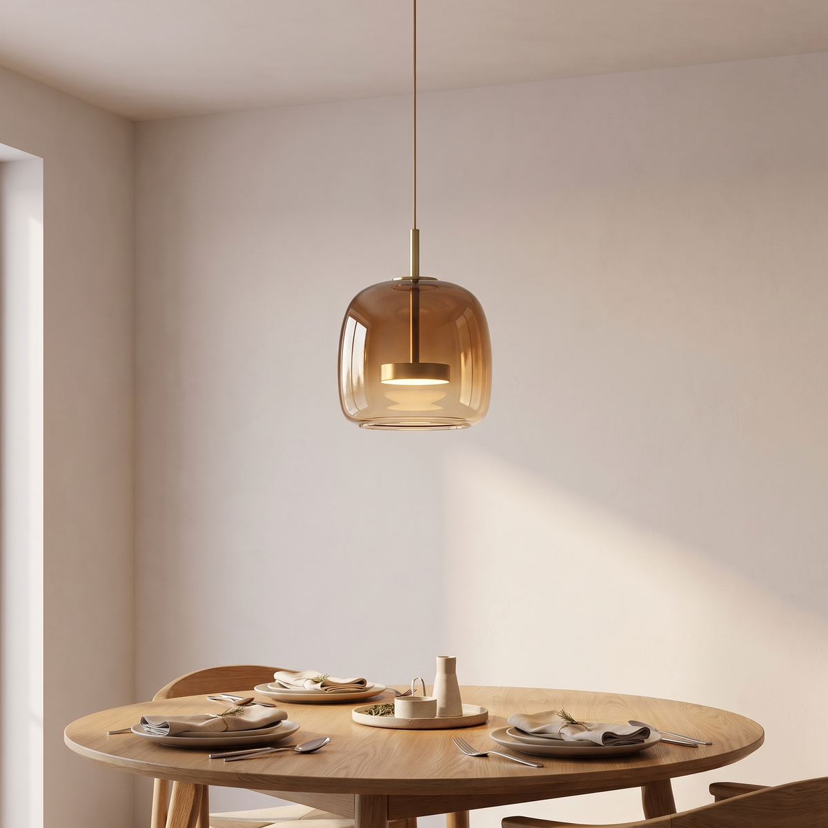 Single amber glass pendant light hanging above a round oak dining table