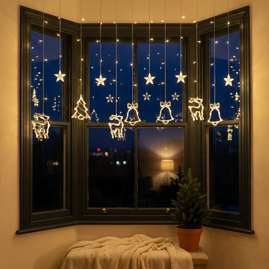 Warm white reindeer, star and bell LED curtain lights in a window