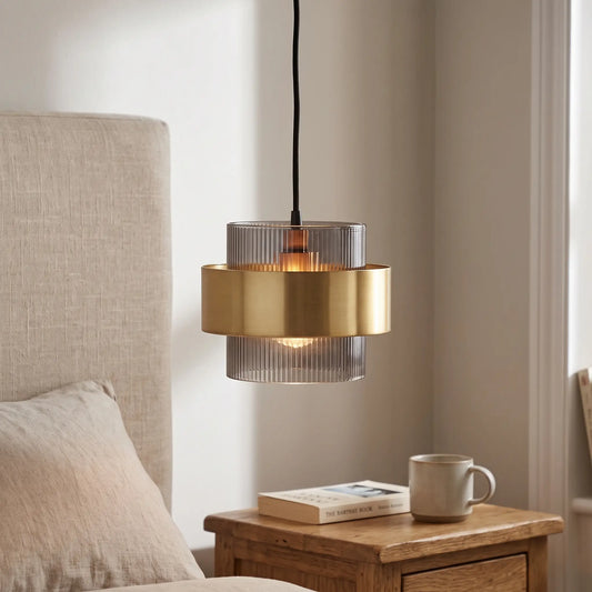 Smoked glass pendant light with gold band – beside a bed