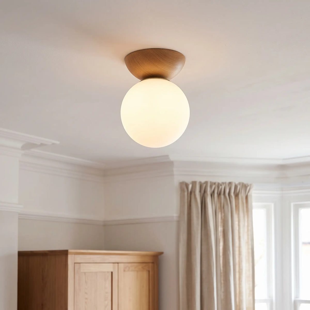 Wood and opal glass globe semi flush ceiling light – Teak – in a bedroom