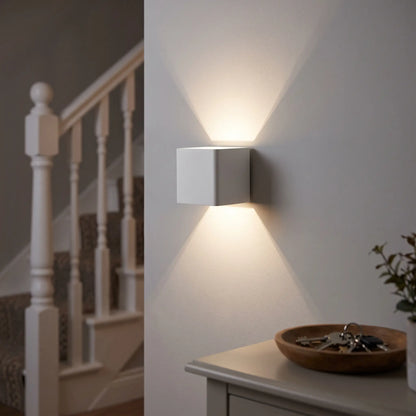 White cube up and down wall light on a hallway wall by the stairs