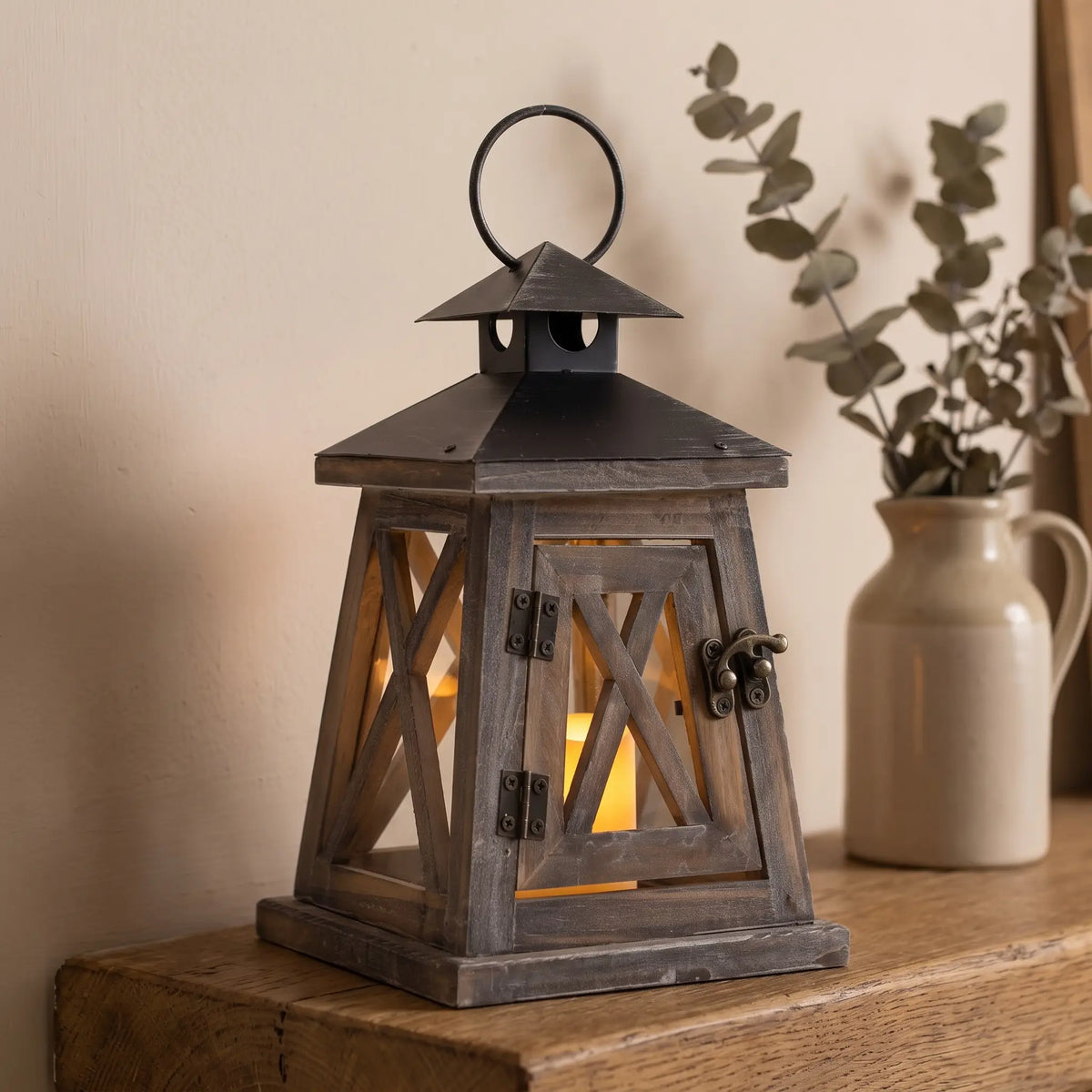 Brown wooden cottage candle lantern on a mantelpiece, 22cm
