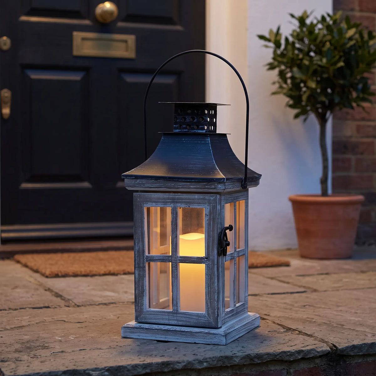 Grey wash wooden candle lantern on a front doorstep at dusk, 26cm