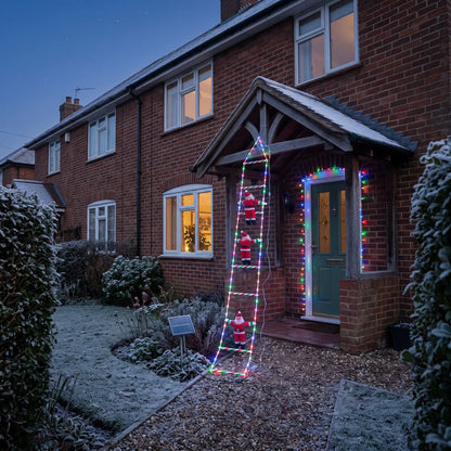 Solar climbing Santa ladder lights on the porch of a brick house at dusk
