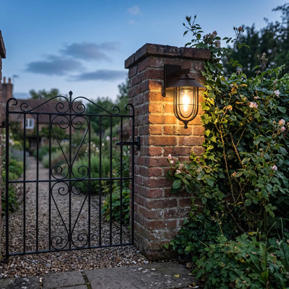 Black cage outdoor wall lantern, 29cm, on a gate pillar