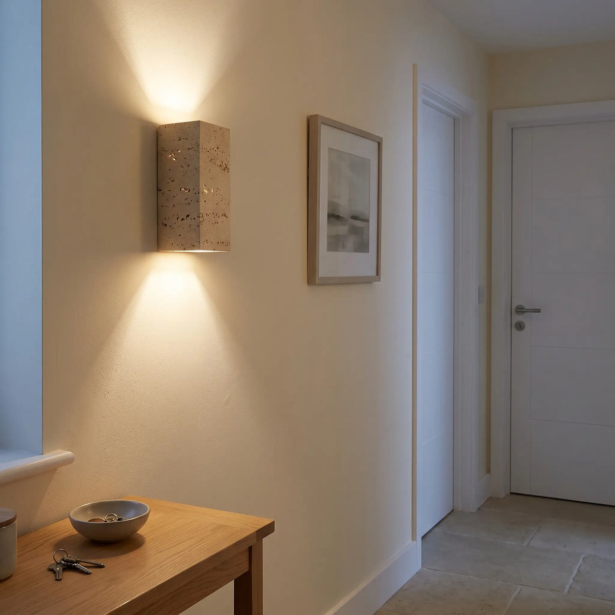 Tall travertine up down wall light in a hallway