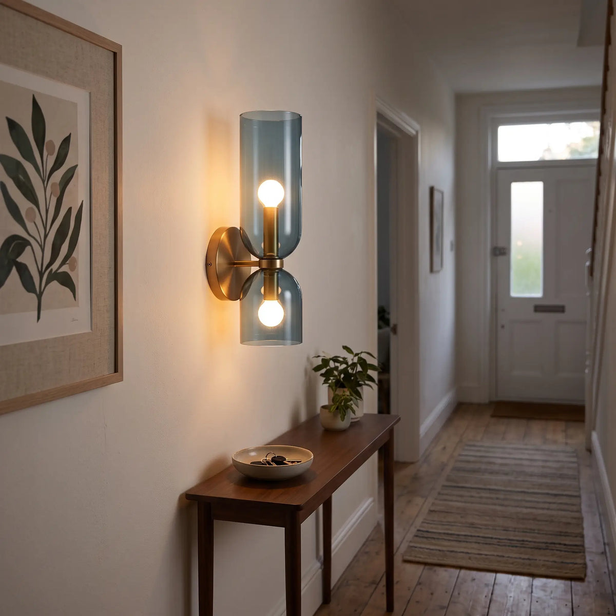 Blue glass cylinder wall light in a hallway