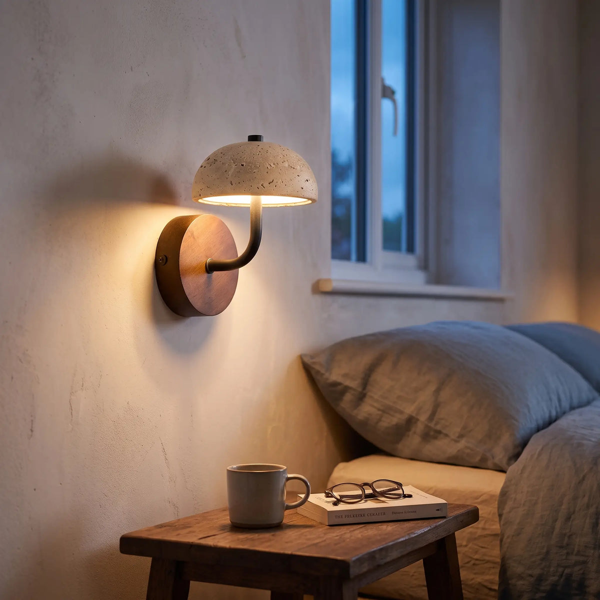Travertine stone dome wall light on a wooden backplate above a bedside table